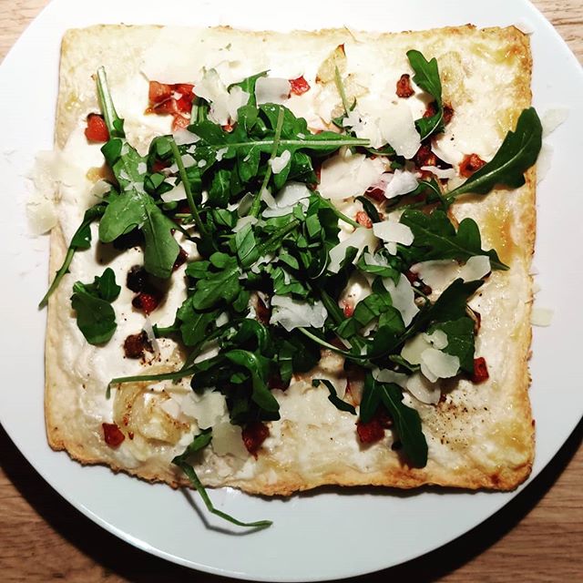 Pizza with cream, pancetta, roquette and parmesan